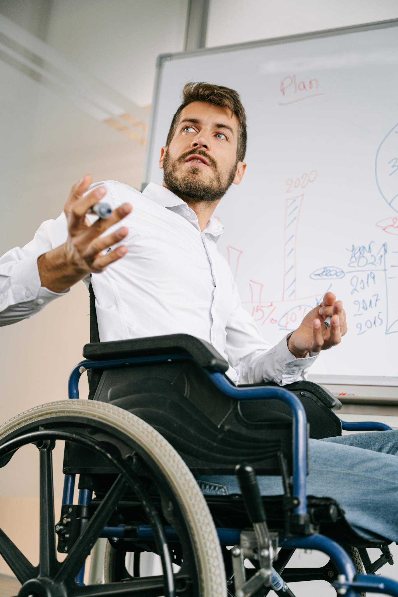 Confident business professional in wheelchair presenting ideas in office setting.